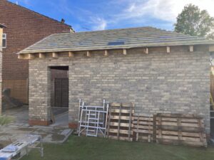 Roof taking shape with hip (inclined part) clearly visible at rear of garage 